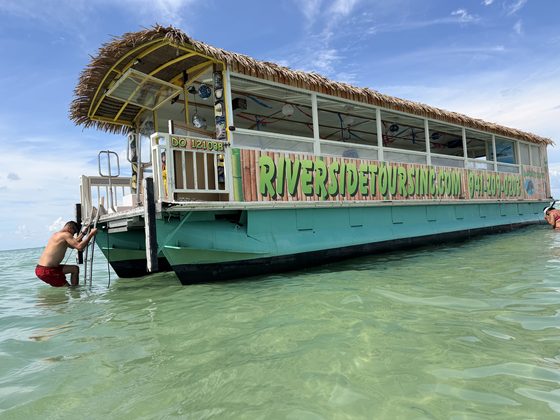 The River Skipper II anchored at a Gulf sandbar in clear water