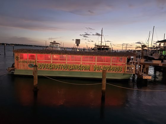The River Skipper II lit up at the dock at sunset