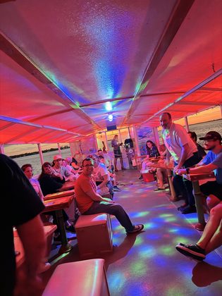 Guests on board under the party lights at sunset