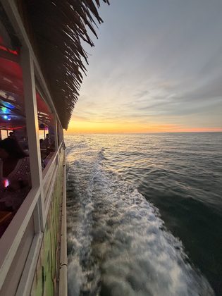 Sunset over the water from the deck of the tiki boat