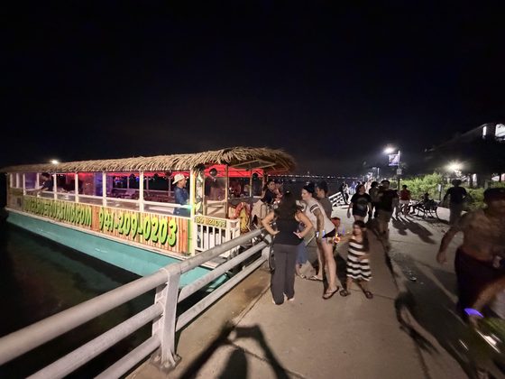 The tiki boat lit up at night on the Bradenton Riverwalk